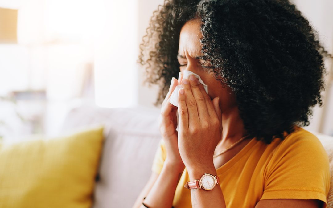 Home, woman and sick with toilet paper for blowing nose, allergy and inflammation of sinus in living room. House, female person and medical virus with tissue for influenza, cold and illness on sofa